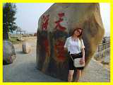 Chinese girl by carved rock on Xiamen Boardwalk Fujian China