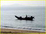 minnan fishermen on  wooden boat cruising the shore